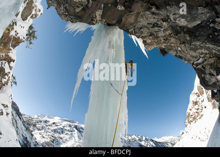 Eine männliche Kletterprofi steigt eine gefrorener Wasserfall-Säule beim Eisklettern in der Nähe von Ouray, Colorado. Stockfoto