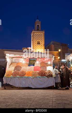 Platz Jemaa el-Fna in der Abenddämmerung mit Trockenobststand und Moschee, Marrakesch, Marokko