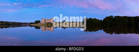 Der Mond hinter Carew Castle am Flussufer Carew Carew, Pembrokeshire, Wales Stockfoto