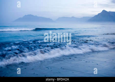 Die Sonne geht über Noordhoek Strand und Chapmans Peak in Cape Town, Südafrika. Stockfoto