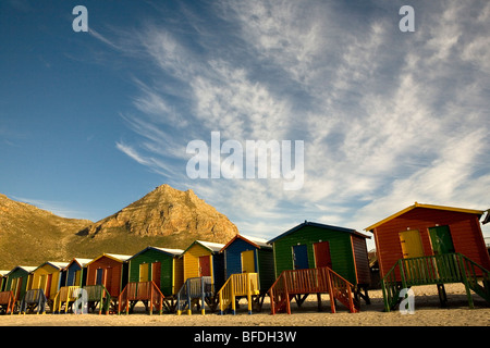 Sunrise leuchtet die bunten viktorianischen Strandhäuser auf Muizenberg Beach auf Kapstadts False Bay Küste, Südafrika. Stockfoto