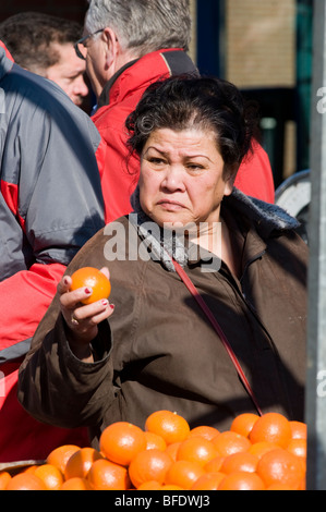 Eine reife Frau kaufen Orangen an einem Marktstand mit Obst in den Niederlanden Stockfoto