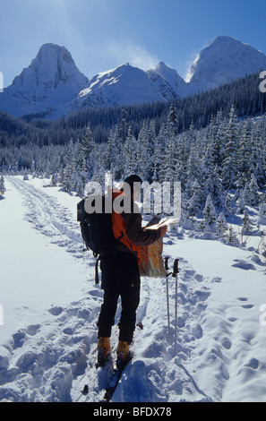 Backcountry Skifahrer doppelte Überprüfung seine Lager in Kananaskis Country, Rocky Mountains, Alberta, Kanada Stockfoto