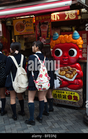 Japanische Schulmädchen auf Takoyaki Stand in Osaka Stockfoto