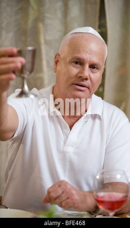 Mann mit Wein Silberpokal am Seder-Abend. Stockfoto