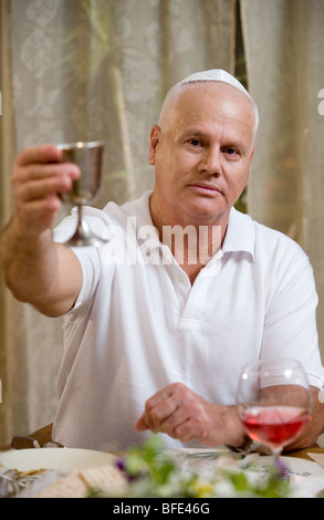 Mann mit Wein Silberpokal am Seder-Abend. Stockfoto