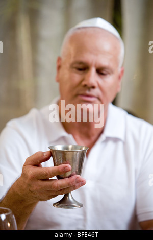 Mann mit Wein Silberpokal am Seder-Abend. Stockfoto