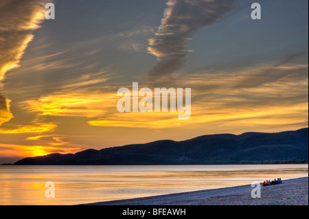 Gruppe von Menschen sitzen am Strand von Agawa Bay bei Sonnenuntergang, Lake Superior, Lake Superior Provincial Park, Ontario, Kanada Stockfoto