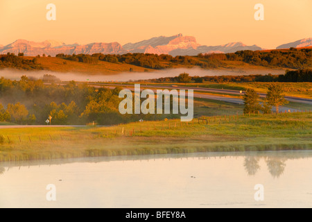 Trans-Canada-Highway in der Nähe von Cochrane, Alberta, Kanada, Berge, Rockies, Sonnenaufgang, Nebel Stockfoto