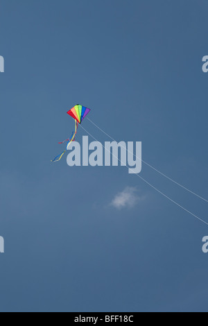 bunten Regenbogen Drachensteigen am Ende des Strings gegen einen strahlend blauen Himmel an einem sonnigen Sommertag Stockfoto