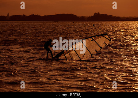 Windsurfer bei Sonnenuntergang am Farmoor Stausee, Oxfordshire, Vereinigtes Königreich Stockfoto