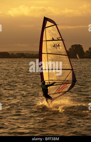 Windsurfer bei Sonnenuntergang am Farmoor Stausee, Oxfordshire, Vereinigtes Königreich Stockfoto