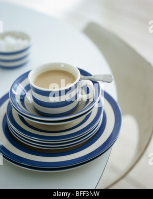 Nahaufnahme des blau + weiß gestreiften Cornish-Ware Cup auf Stapel der passenden Schalen und Teller Stockfoto