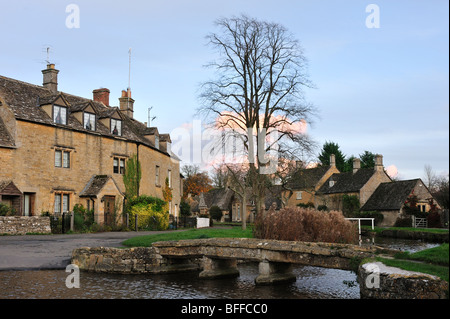 LOWER SLAUGHTER, GLOUCESTERSHIRE - 02. NOVEMBER 2009: Blick über den Fluss Windrush und die Fußgängerbrücke Stockfoto