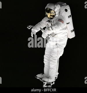 NASA-Astronaut stehen am Roboterarm des Space Shuttles im Weltraum Stockfoto