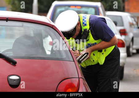 Polizist stellt ein Ticket zu einem Fahrer eines Autos, England, UK Stockfoto