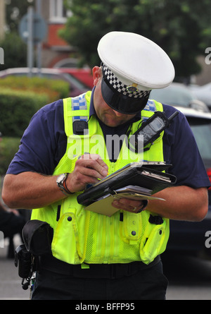 Polizist stellt ein Ticket zu einem Fahrer eines Autos, England, UK Stockfoto