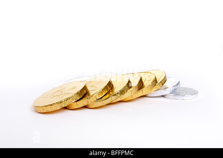 Gold und Silber Folie verpackt Schokolade Euro vor weißem Hintergrund mit flachen Fokus. Stockfoto