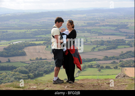 Junges Paar beim Spaziergang mit ihrem jungen Baby. Stockfoto