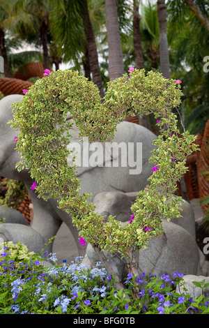 Elefant Skulptur und Herzförmige ausgebildet blühende Laub an Suan oder NongNooch Nong Nooch Tropical Botanical Garden Resort, Pattaya, Thailand Stockfoto