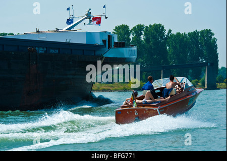 Klassischen hölzernen Motorboot vorbei Frachtschiff auf Rhein Stockfoto