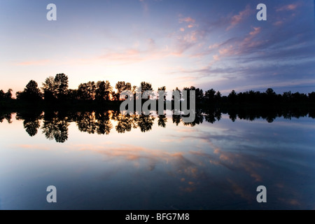 Wolken reflektieren in einem Fluss in Carburn Park in Calgary Alberta bei Sonnenuntergang. Stockfoto