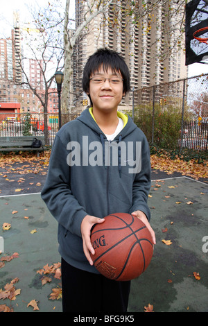 Porträt eines chinesisch-amerikanischen Pre Teen auf einem Basketballfeld. Stockfoto