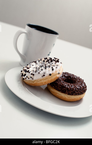 eine Tasse heißen Kaffee und zwei leckere Donuts Stockfoto