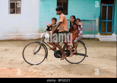 Indische Teenager und Kinder mit dem Fahrrad in einem indischen Dorf. Andhra Pradesh, Indien Stockfoto