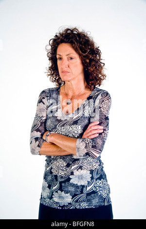 Mit auf der Brust verschränkten Armen stehen zeigt eine defensive Stimmung in dieser Frau. Stockfoto