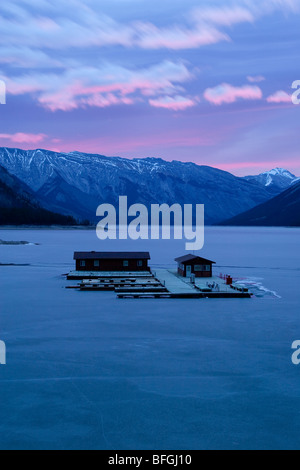 Schwimmdock auf gefrorene Lake Minnewanka bei Sonnenaufgang, Banff Nationalpark, Kanada Stockfoto