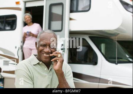 Ältere Mann sitzt vor einem Wohnwagen Stockfoto