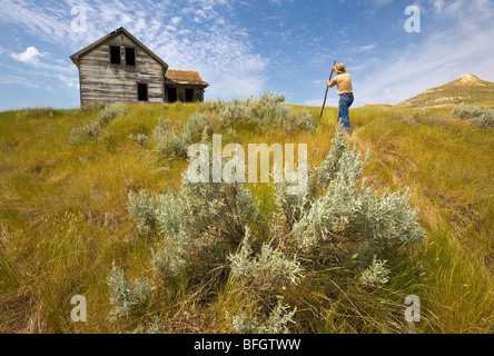 Ein Mann schaut auf einem verlassenen Bauernhaus, Big Muddy Badlands, Saskatchewan, Kanada Stockfoto