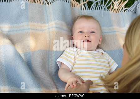 Mutter beugte sich über Baby auf Teppich, Ansicht von oben Stockfoto