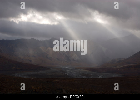 Lichtstrahlen, die Regenwolken über Polychrome Pass und Toklat River Valley durchschimmern. Denali Nationalpark, Alaska, Nordamerika Stockfoto