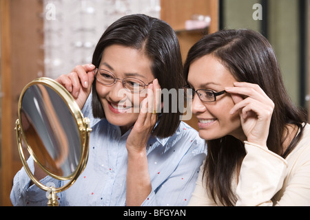 Zwei Frauen, die versuchen auf Brillen im Shop Stockfoto