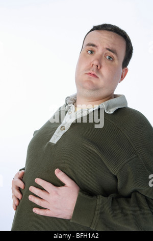 Mid-Adult Mann mit Händen auf dem Bauch mit Übergewicht Stockfoto