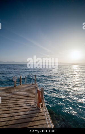 Sonnenaufgang über Taba Heights, Taba, Sinai, Rea Meer, Ägypten, Afrika, mit ruhigen blauen Wasser in den Vordergrund und Tauchen Steg. Stockfoto