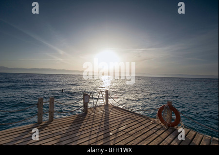 Sonnenaufgang über Taba Heights, Taba, Sinai, Rea Meer, Ägypten, Afrika, mit ruhigen blauen Wasser in den Vordergrund und Tauchen Steg. Stockfoto