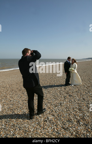 Hochzeitsfotografen fotografieren oder die Aufnahme einer Braut und Bräutigam am Strand Stockfoto