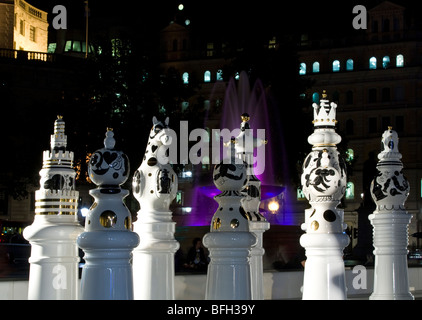 Riesige Schachfiguren in Trafalgar Square in London in der Nacht mit Brunnen Stockfoto