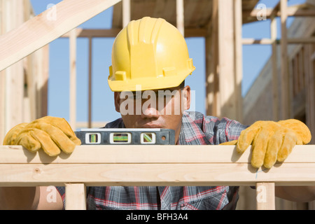 Bauarbeiter mit Wasserwaage auf Gebäude Stockfoto