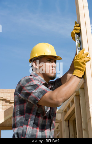 Bauarbeiter mit Wasserwaage auf Gebäude Stockfoto