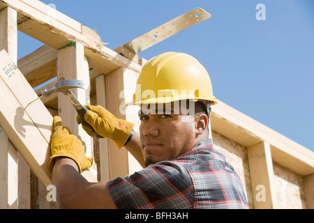 Bauarbeiter mit Hammer auf Gebäude Stockfoto