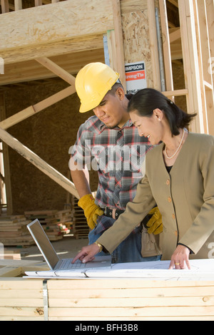 Bauarbeiter mit Laptop mit Landvermesser Stockfoto
