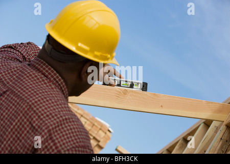 Bauarbeiter mit Wasserwaage auf Gebäude Stockfoto