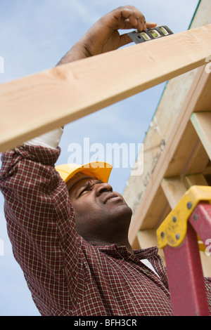 Bauarbeiter mit Wasserwaage auf Gebäude Stockfoto