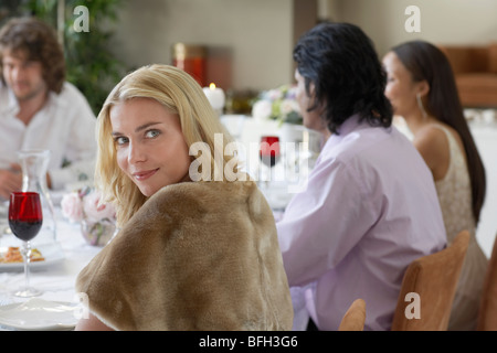 Junge Frau sitzt am Tisch der förmlichen Dinner-party Stockfoto