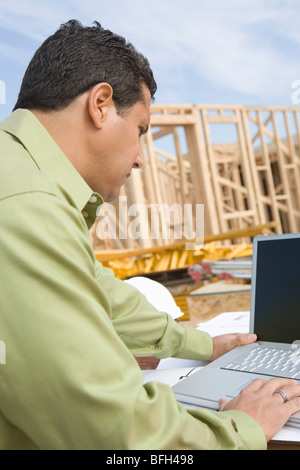 Architekt mit Laptop auf Baustelle Stockfoto