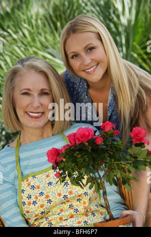 Porträt von zwei Frauen mit Blumen im Garten Stockfoto